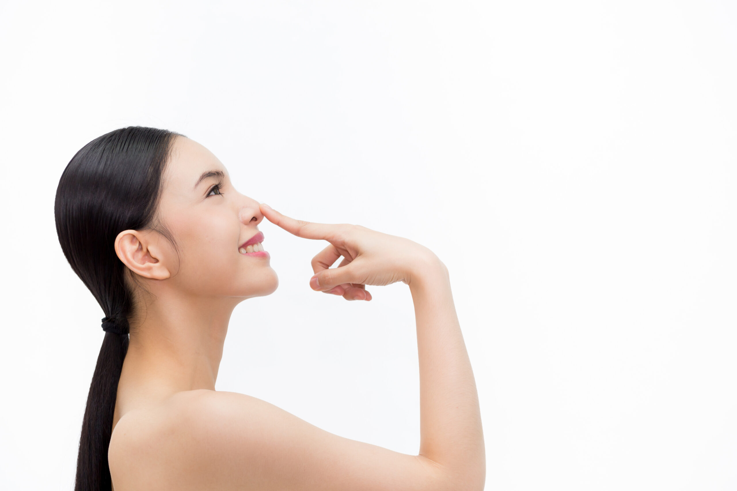 Young attractive woman touching her nose with fingertip over isolated white background